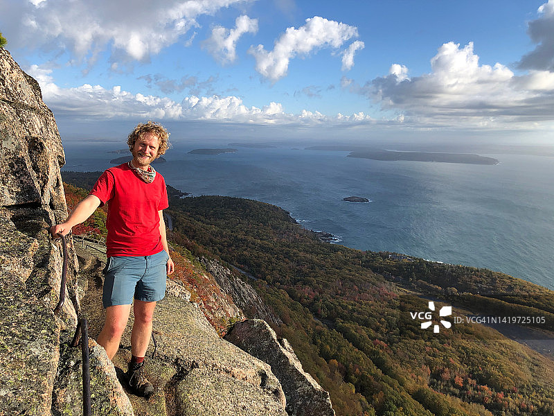 悬崖上的男性徒步旅行者——在自然中微笑图片素材