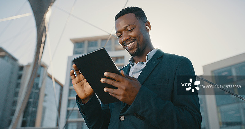 商务男士在城市行走时使用5G移动技术进行音乐和通信。在互联网上听音乐，在城市背景下进行规划图片素材