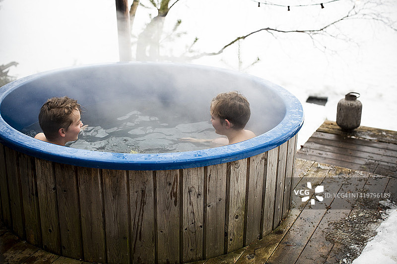 冬季男孩们在热水浴缸中享受图片素材
