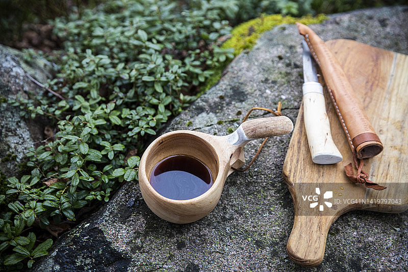 岩石上带砧板的茶杯和刀图片素材