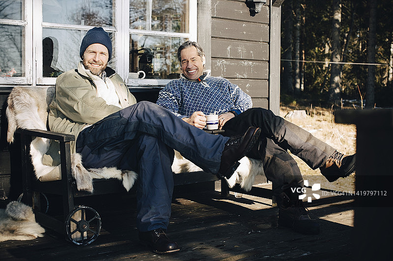 坐在前廊的快乐成熟男人全身像图片素材