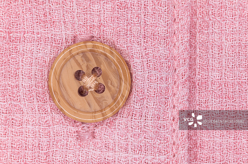 白色针织面料的纽扣和纹理，粉色背景图片素材