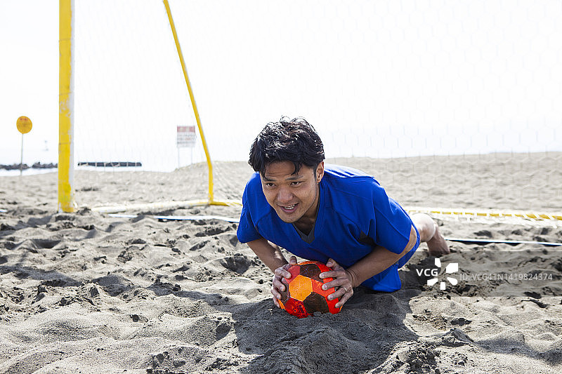 在海滩上做俯卧撑的年轻亚洲女运动员图片素材
