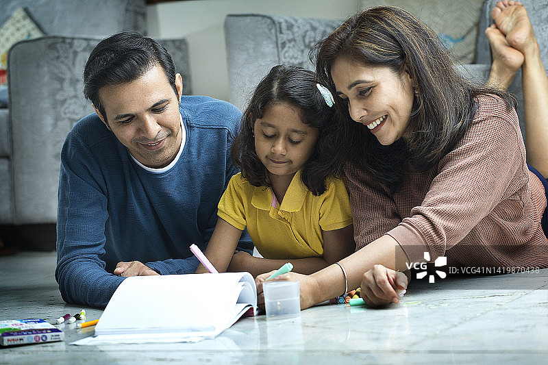 女人躺在地板上教女儿图片素材