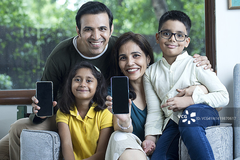 父母和孩子展示智能手机空白屏幕图片素材