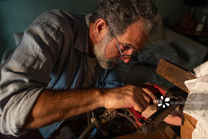 修复旧扶手的活力老人图片素材