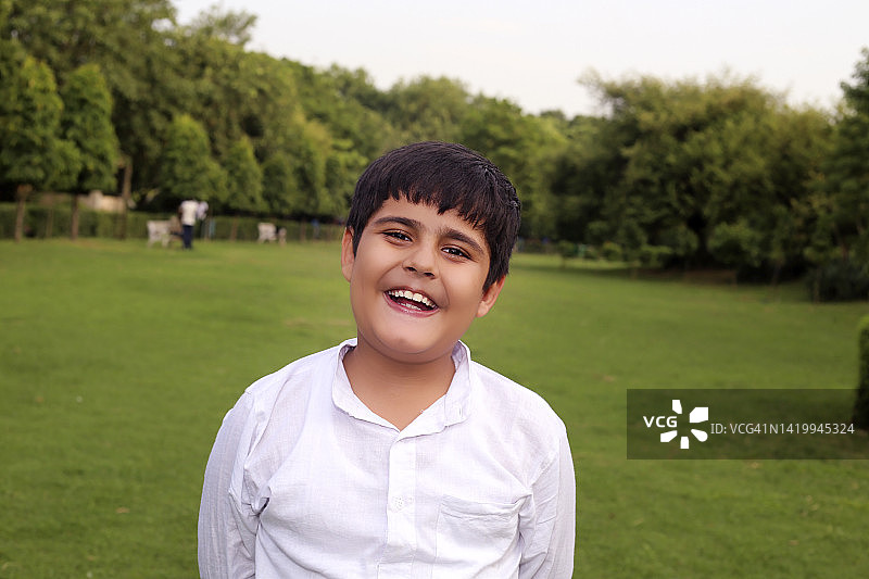 春天户外自然光下的露齿微笑儿童肖像图片素材
