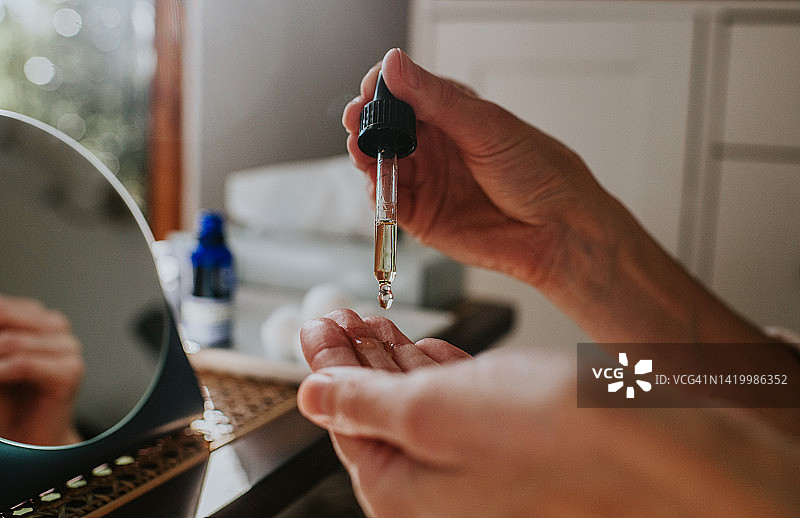 用化妆油滋润双手的女人图片素材