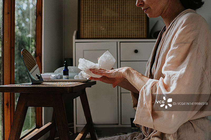 用一次性纸巾擦去多余化妆品的女子图片素材