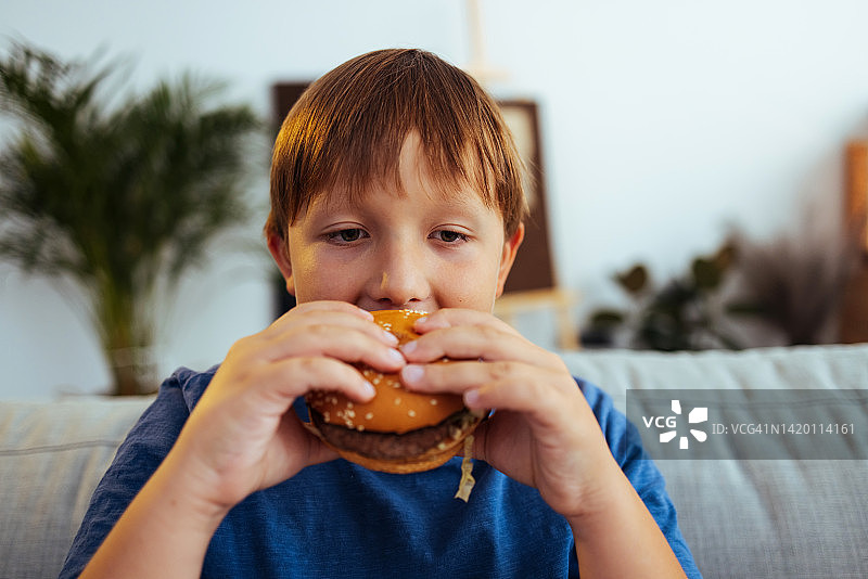 男孩拿着一个经典的美式汉堡图片素材