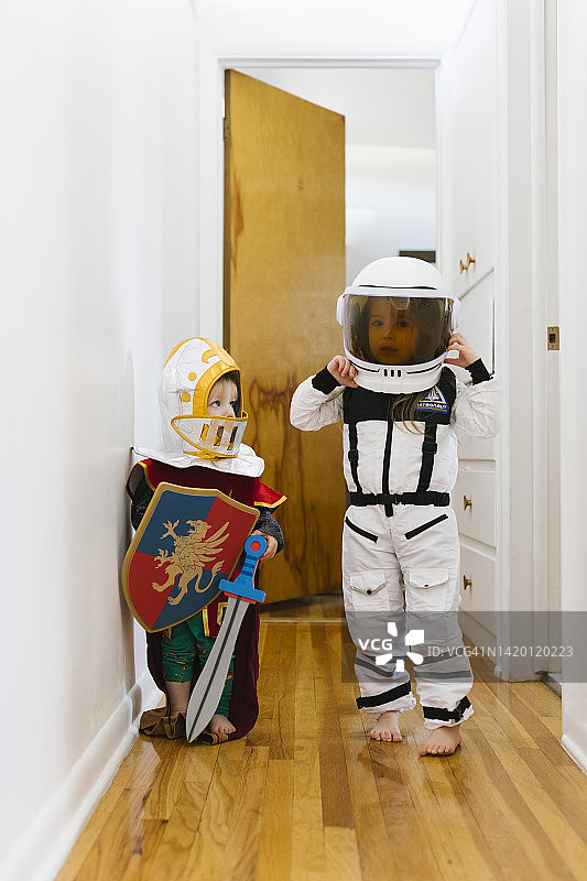 （2-3岁）装扮成骑士的幼儿和装扮成宇航员的女孩在家玩耍图片素材