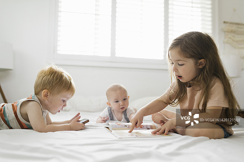 兄妹阅读和使用手机（6-11个月，2-3岁）图片素材