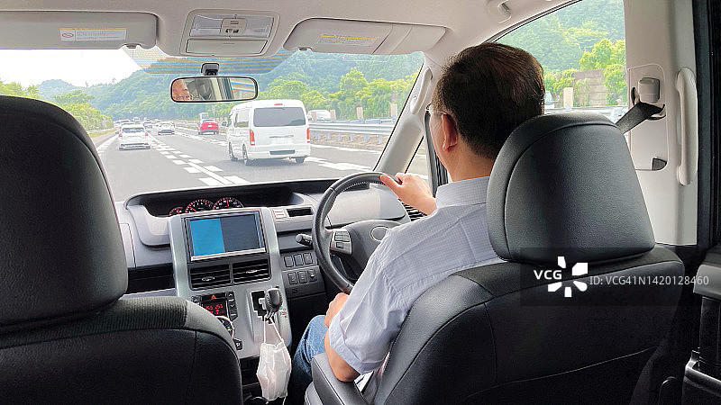 乘客视角：男子在高速公路上开车的后视图（智能手机拍摄）图片素材
