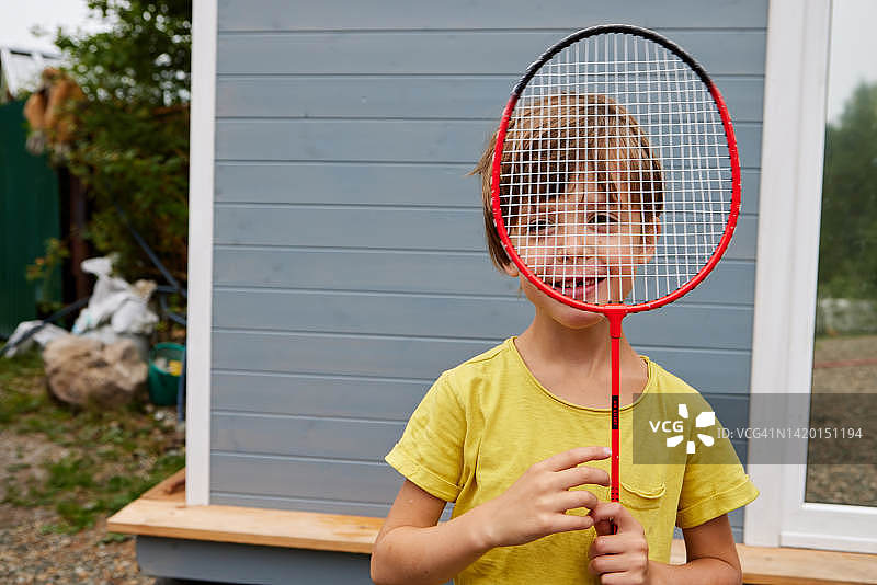 手持羽毛球拍的男孩肖像图片素材