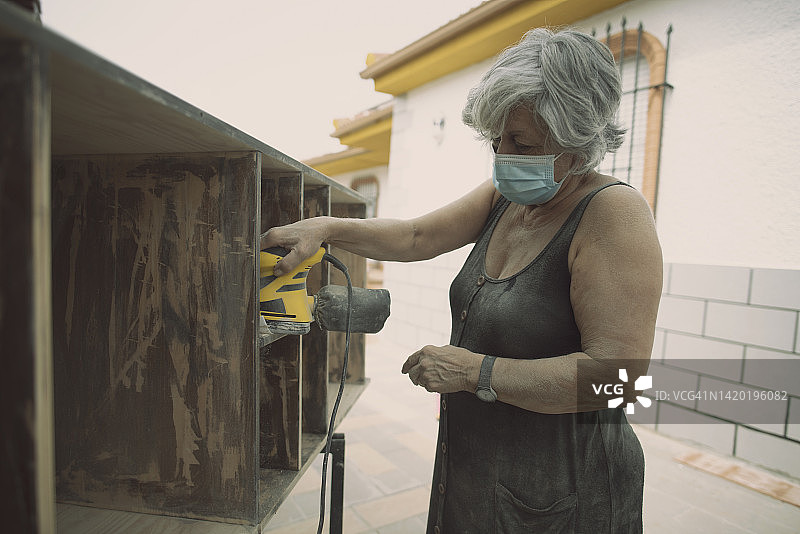 70岁女人在家打磨家具图片素材