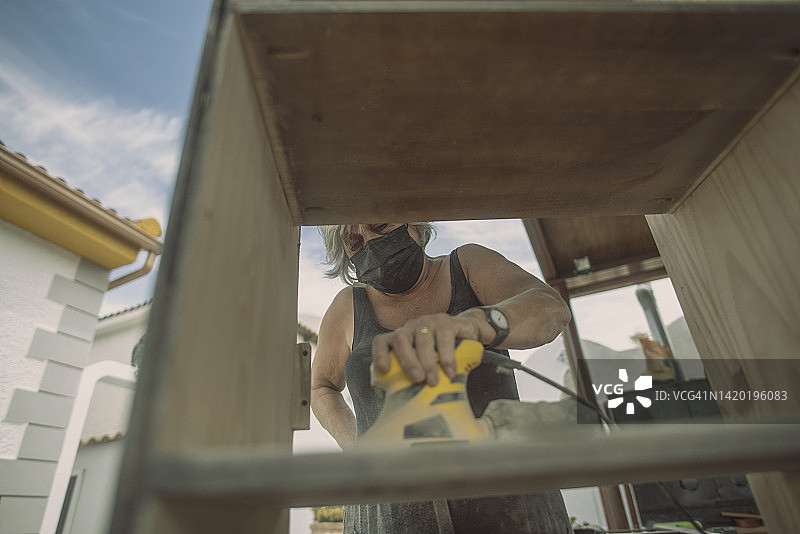 70岁女人在家打磨家具图片素材