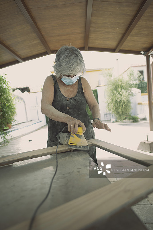 70岁女人在家打磨家具图片素材