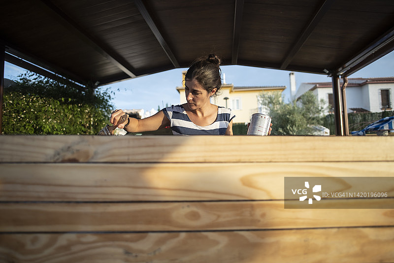 女人在自家刷漆翻新家具图片素材
