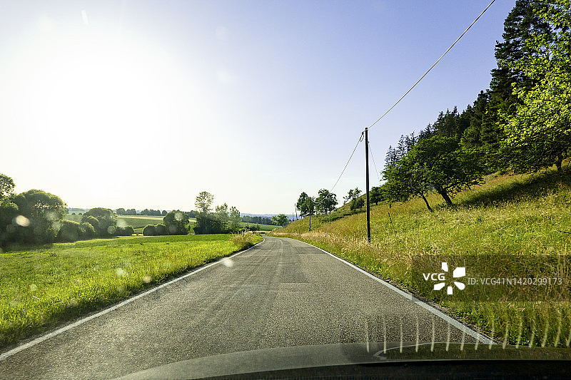 驾驶在穿过农田的乡村公路上图片素材