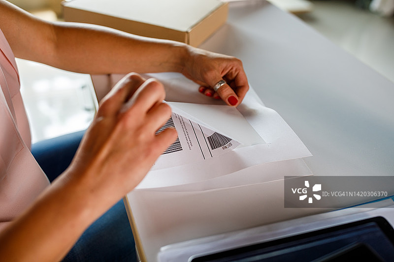 女人撕下标签准备贴在包裹上图片素材