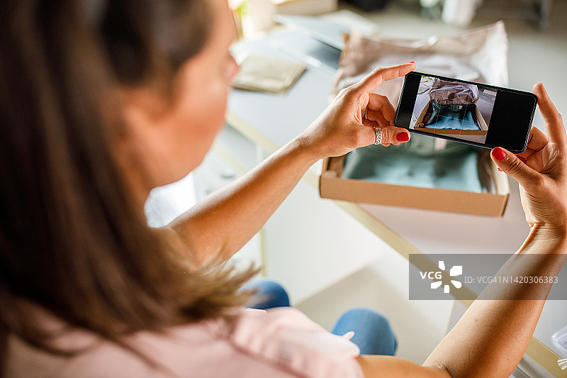 商务女性拍摄纸箱里包装的衣物图片素材