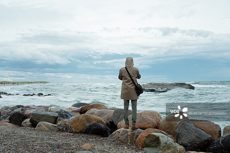 在沙滩上走过远处沙丘的年轻男人图片素材