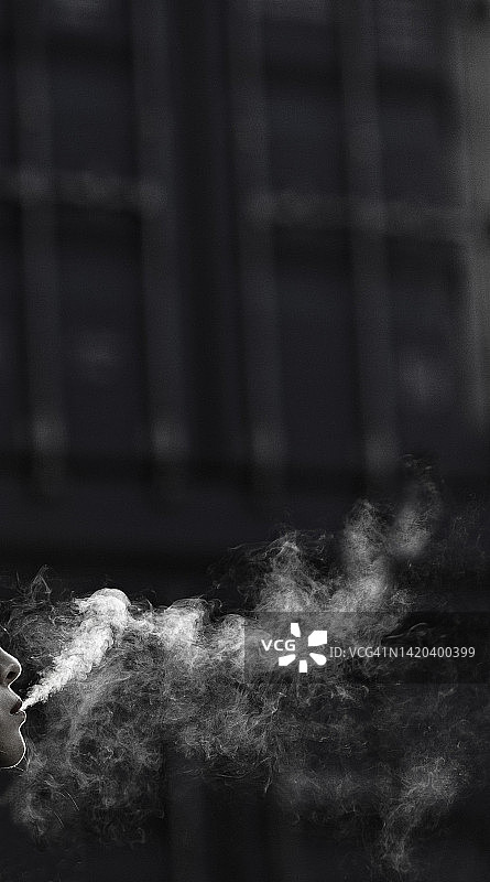 在户外吸烟的年轻女人图片素材