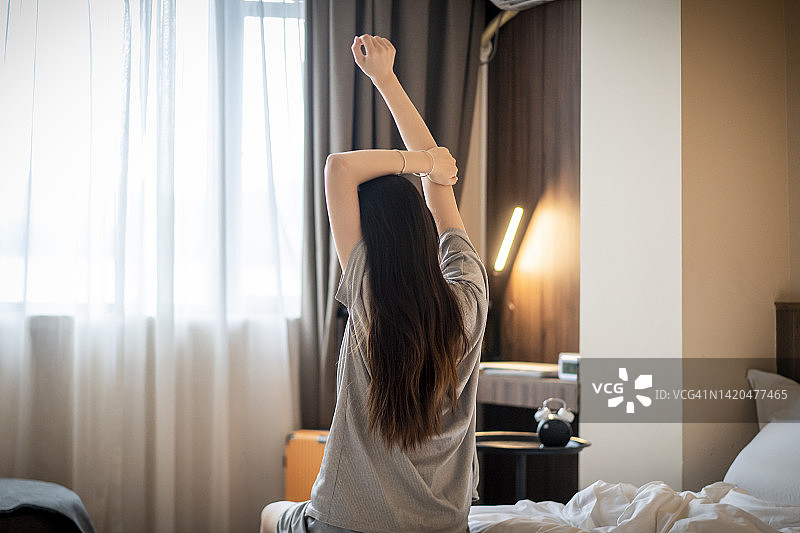 年轻亚洲女性醒来并伸展身体图片素材