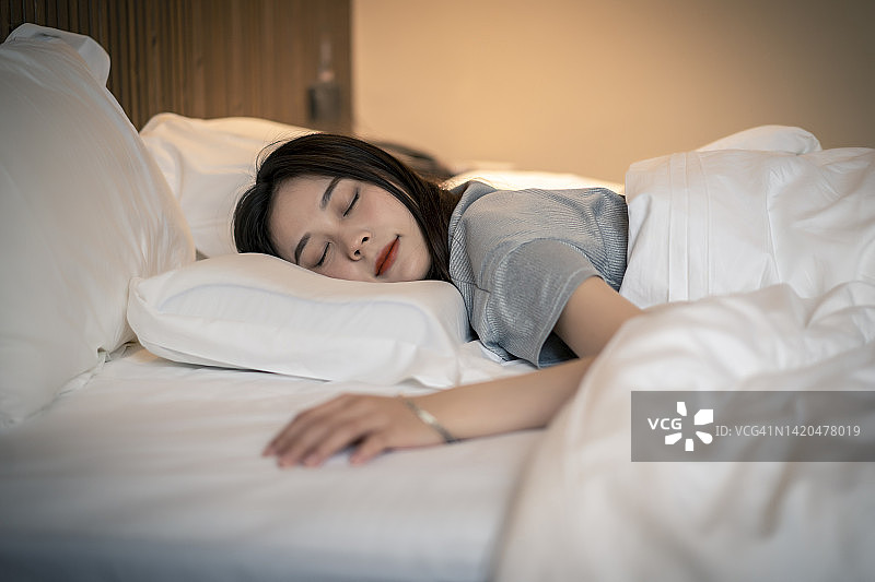 年轻的亚洲女人在酒店睡觉图片素材