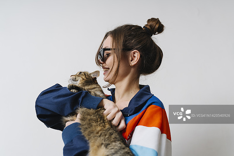 手持虎斑猫的微笑女人，白色背景图片素材