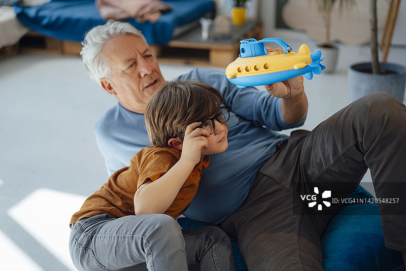 祖孙俩在家检查潜艇玩具图片素材