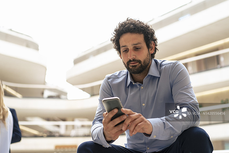 商人办公室用手机发短信图片素材