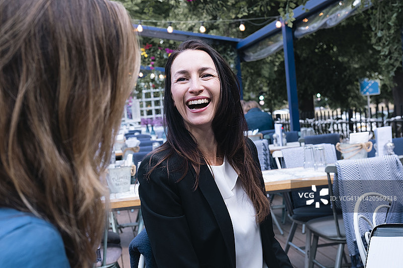 在餐厅里和同事一起欢笑的成熟女商人图片素材