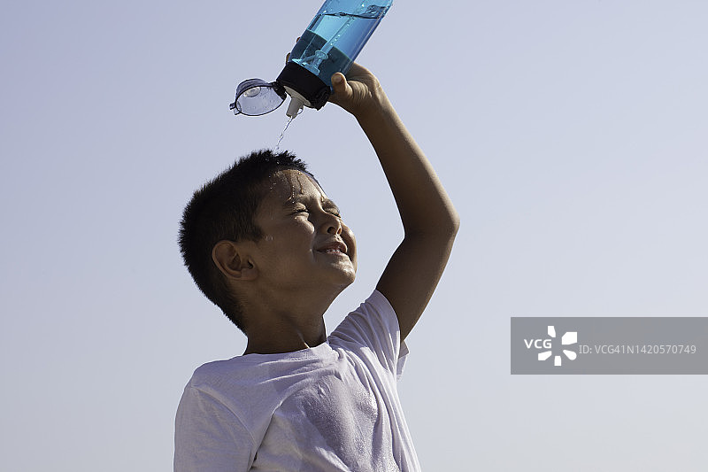 男孩往头上倒水图片素材