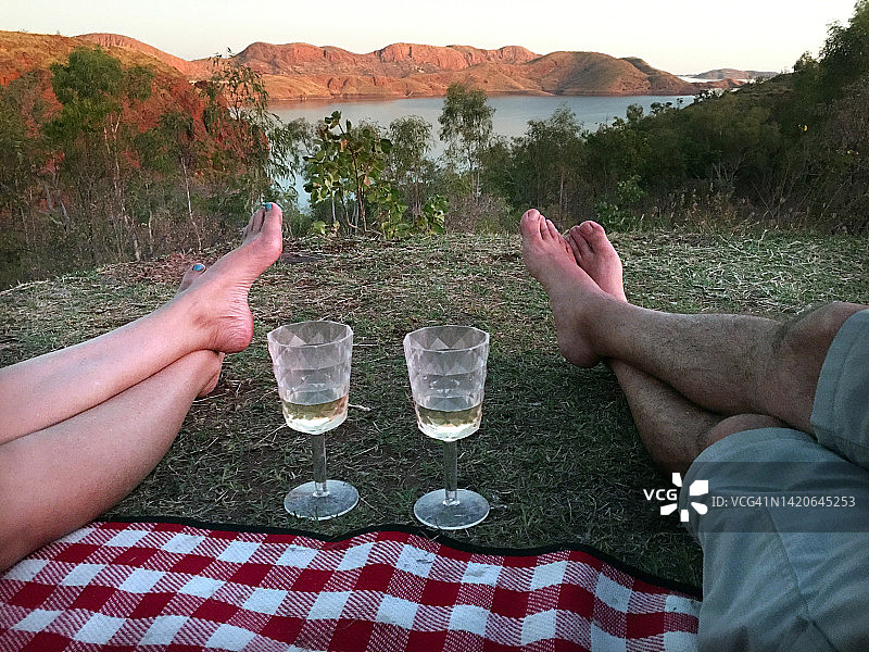 澳大利亚情侣在野餐垫上欣赏阿盖尔湖，品尝白葡萄酒图片素材