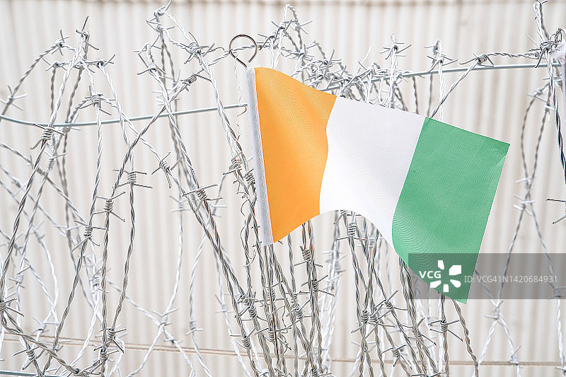 科特迪瓦国旗在带刺铁丝网上图片素材