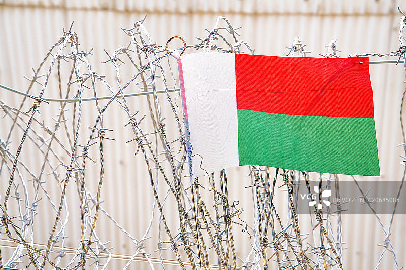 带刺铁丝网上的马达加斯加国旗图片素材