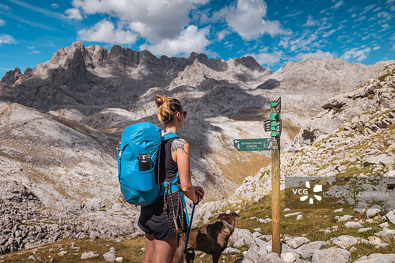 年轻女子在国家公园背包旅行时看路标图片素材