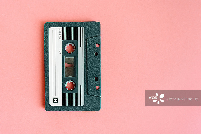 粉色背景上的旧绿色卡式磁带俯视图：右侧有复制空间图片素材