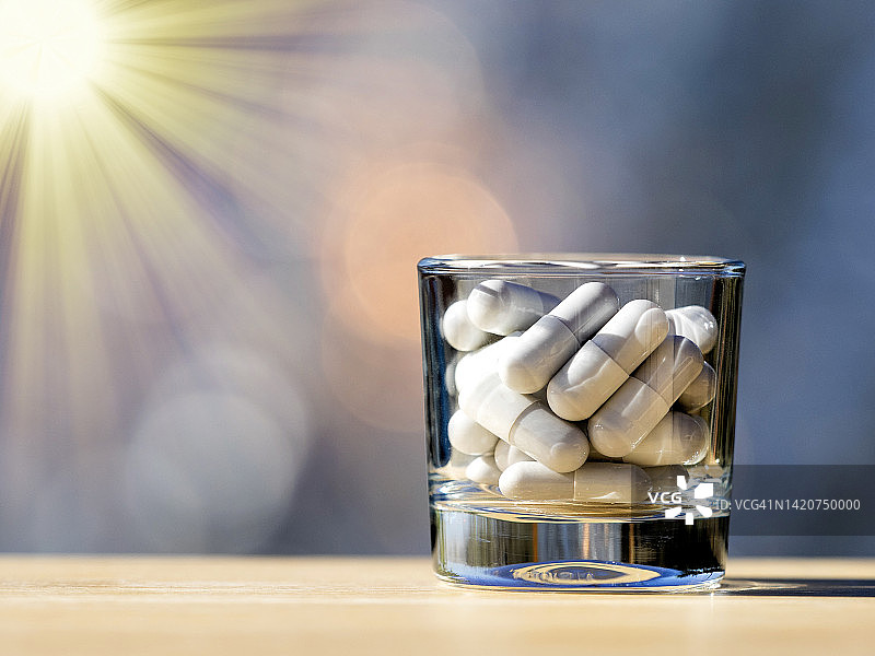 阳光照射下小玻璃杯中的大剂量药物图片素材