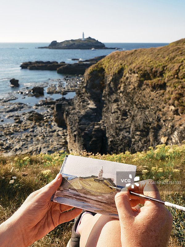 女人沿着康沃尔海岸线绘画图片素材