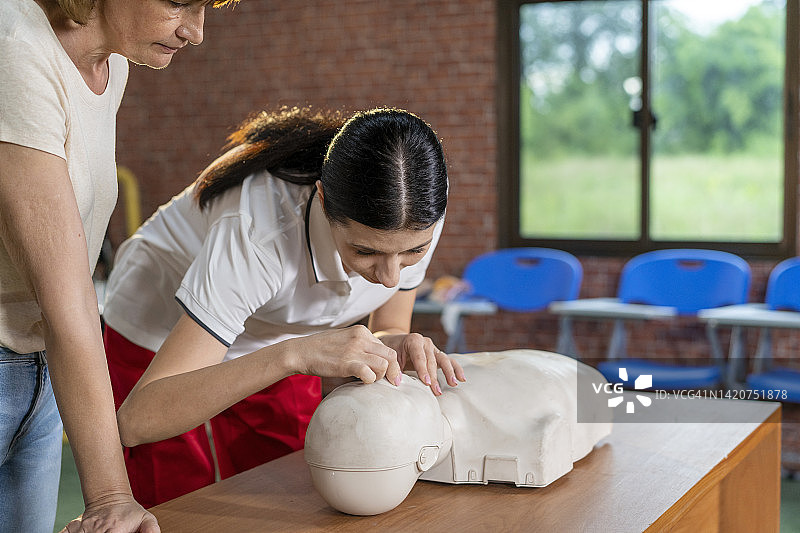 女人演示心肺复苏假人图片素材