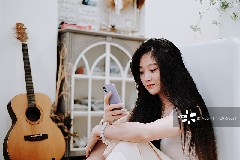 在家使用智能手机的亚洲女性图片素材
