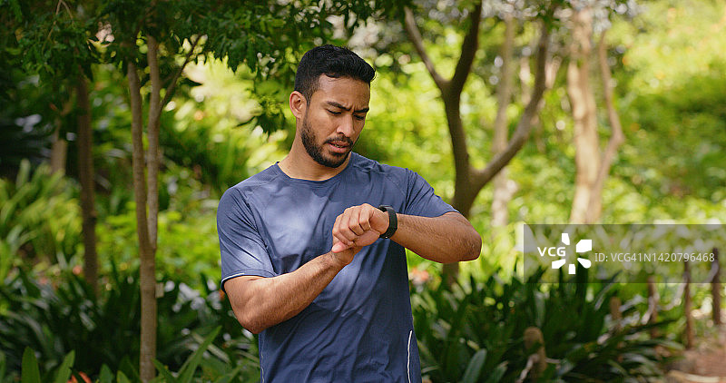 运动跑步者或健身男士训练时查看手表图片素材