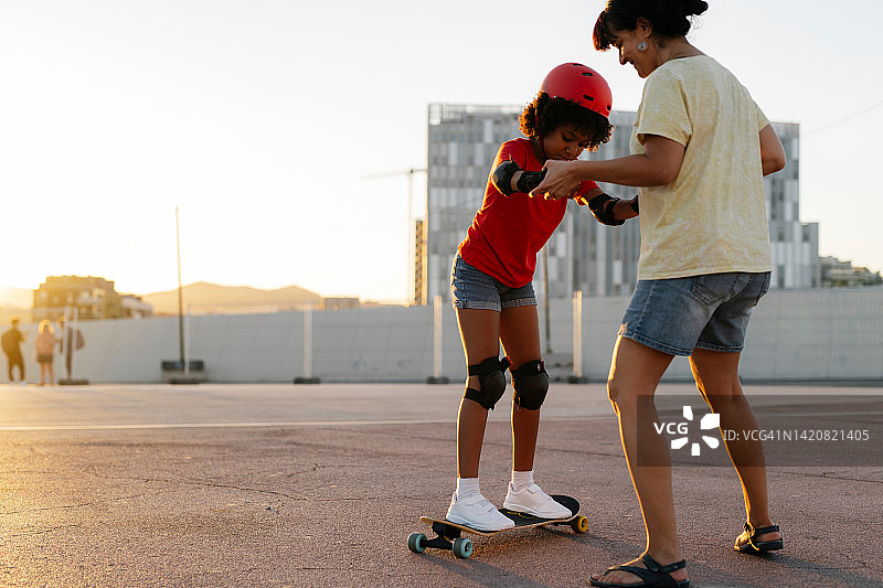 母亲教她的养女玩滑板图片素材