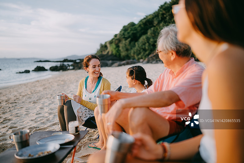 女士在日本冲绳海滩日落时享受美好时光图片素材