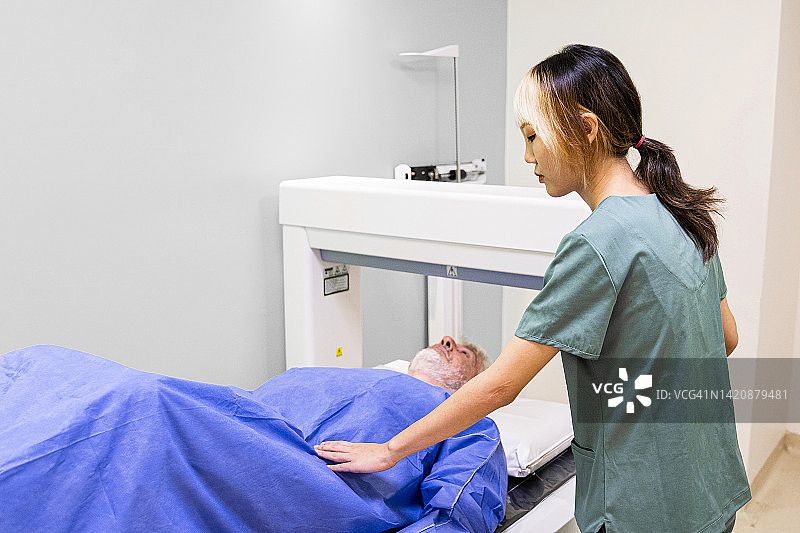 正在为患者进行骨密度检查的技术员图片素材