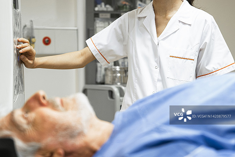 男病人接受核磁共振扫描，技术员在背景中图片素材