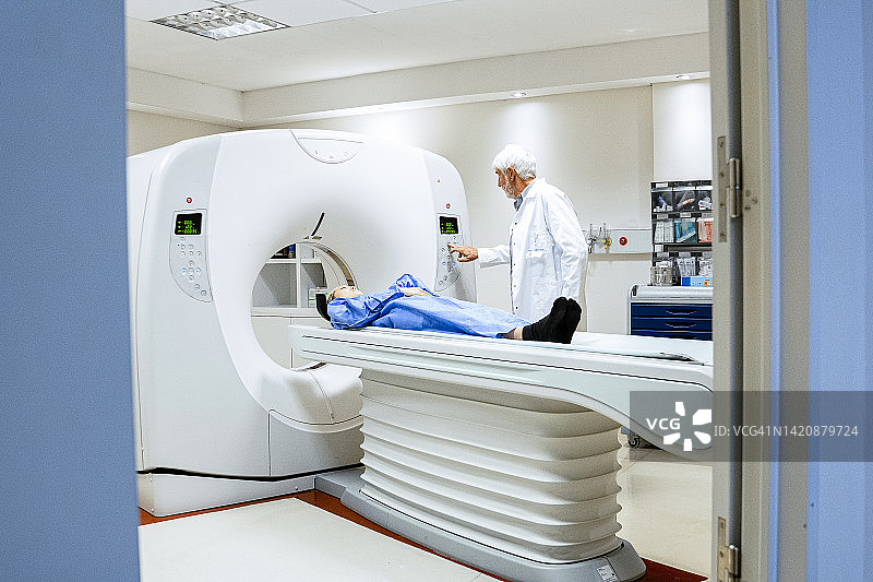 医生操作MRI扫描仪为女性患者进行诊断成像的设施广角视图图片素材