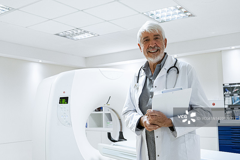 站在核磁共振扫描仪前的年长男医生半身像图片素材